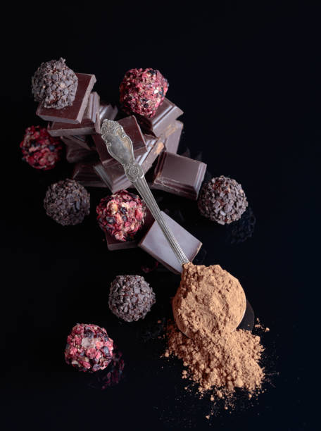 istock Chocolate candies, broken chocolate pieces and spoon with cocoa powder. 1079024132