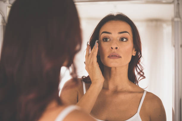 istock Woman applying face foundation in front of mirror 1079029106