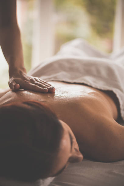 istock Massage therapist applying oil on woman's body 1079057806