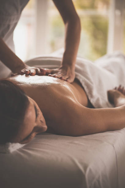 istock Massage therapist applying oil on woman's body 1079057808