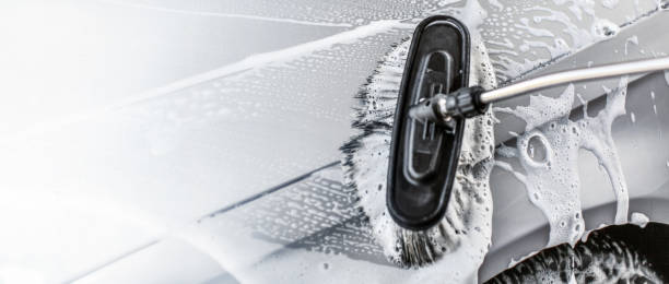 istock Brush leaving strokes in shampoo and foam. Space for text on the left, self service carwash banner. 1079059582