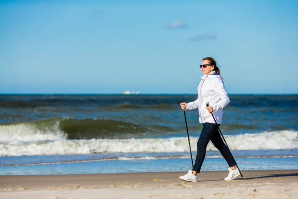 nordic walking-menschen training am strand - power walken stock-fotos und bilder