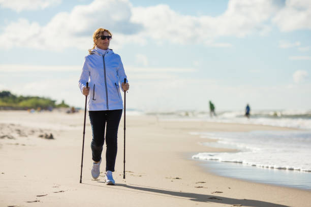 ビーチで北欧の歩く人々 のトレーニング - nordic walking walking relaxation exercise women ストックフォトと画像