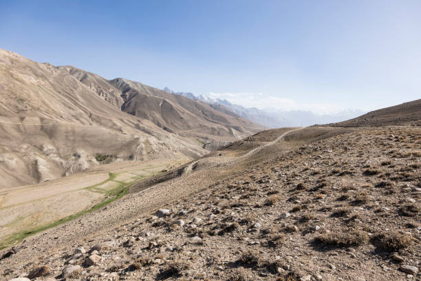 pamir highway dans le paysage désertique de montagnes du pamir au tadjikistan. l’afghanistan est sur la gauche - pamirs photos et images de collection