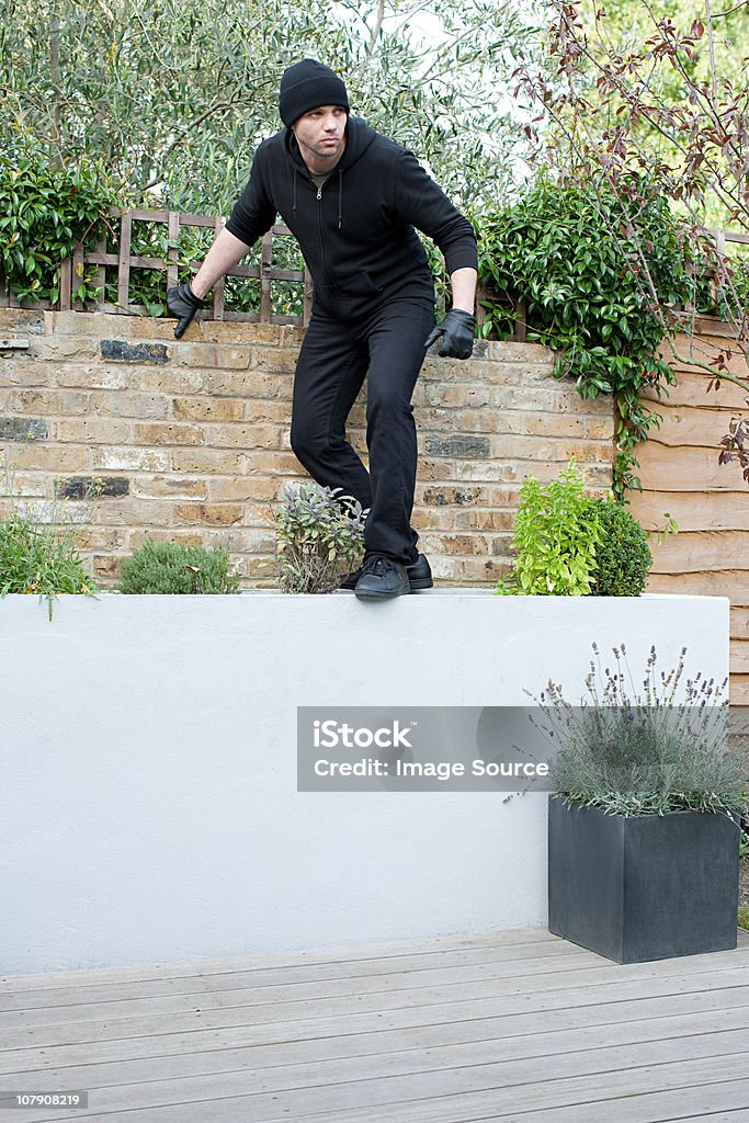 Burglar climbing on wall  Back Door Stock Photo