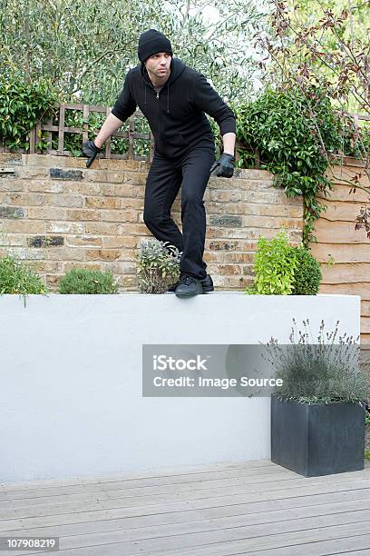 Burglar Climbing On Wall Stock Photo - Download Image Now - Back Door, Activity, Adult