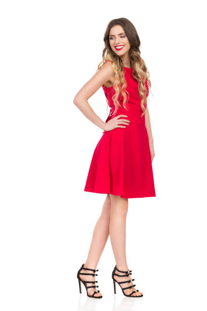 istock Smiling Woman In Red Dress Is Looking Down Over Shoulder 1079087084
