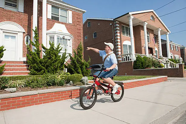 Photo of Paperboy with bike throwing newspaper