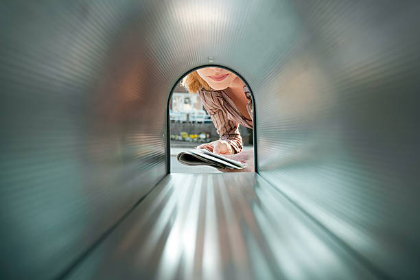 woman collecting mail from mailbox - women suburb mailbox curiosity стоковые фото и изображения