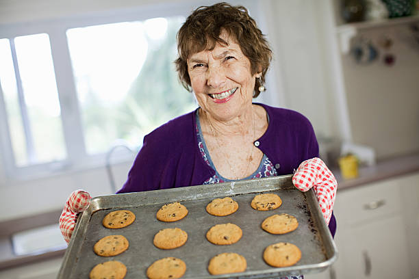 donna anziana con biscotti in casa - adult senior adult traditional culture usa foto e immagini stock