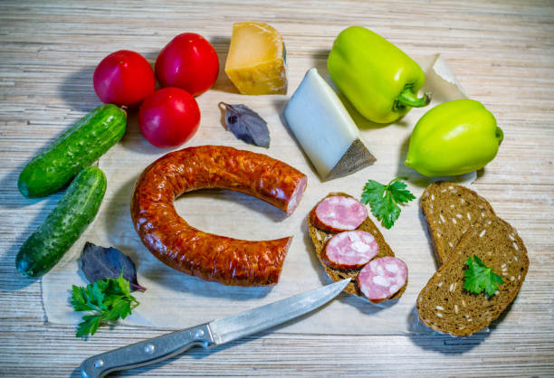 istock Products on the table – smoked sausage, brown bread, cheese and vegetables 1079089710