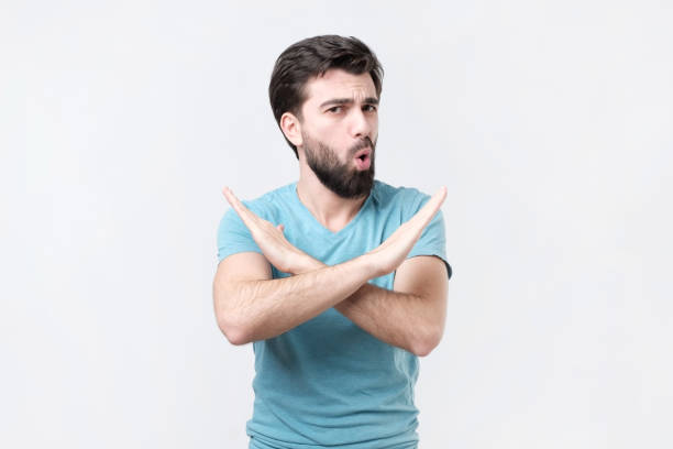 istock Young hispanic man doing no or stop sign isolated on white background. 1079091728