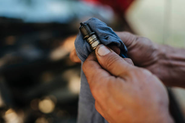 Man checks the spark plug Man checks the spark plug on the old car ignition photos stock pictures, royalty-free photos & images
