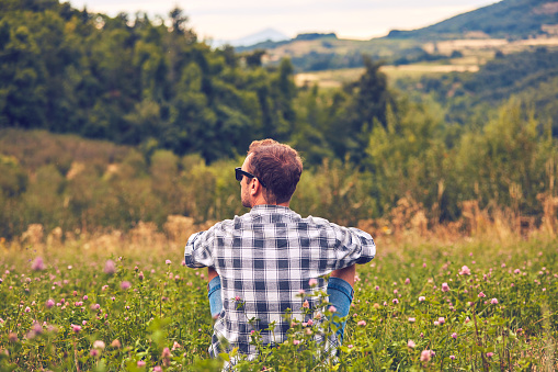 Man taking a break in nature and looking at the distant landscape.