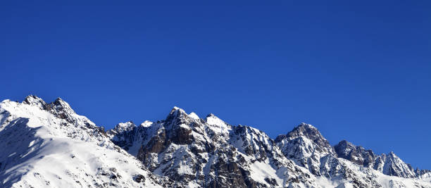 istock Snowy rocks and blue clear sky at cold sun day 1079105404