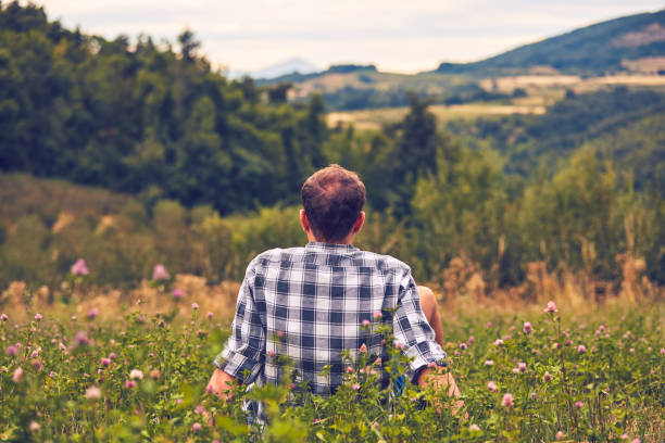 istock Man taking a break in nature and looking at the distant landscape. 1079105966