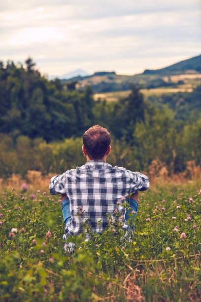 istock Man taking a break in nature and looking at the distant landscape. 1079107116