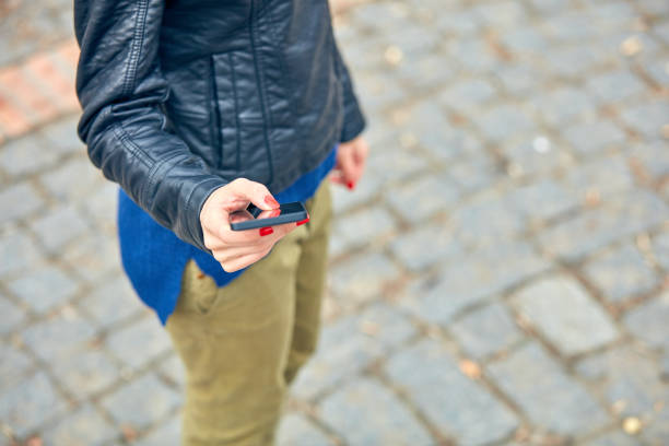Woman using modern smartphone on the street.