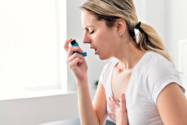 istock An Asthmatic using her inhaler because of breath difficulties 1079107678