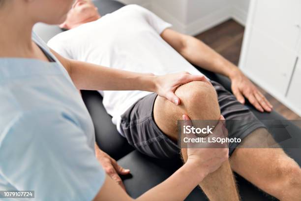 Patient At The Physiotherapy Doing Physical Exercises With His Therapist Stock Photo - Download Image Now