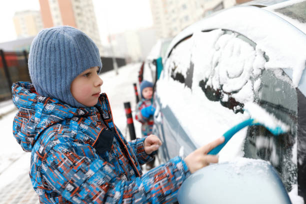 istock Child scraping snow from vehicle 1079125640