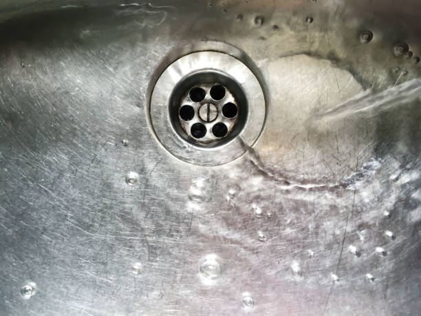 istock Water flows into stainless steel kitchen sink, Abstract Background 1079144248