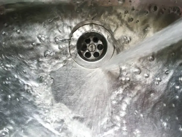 Water flows into stainless steel kitchen sink, Abstract Background