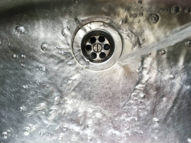 istock Water flows into stainless steel kitchen sink, Abstract Background 1079144272
