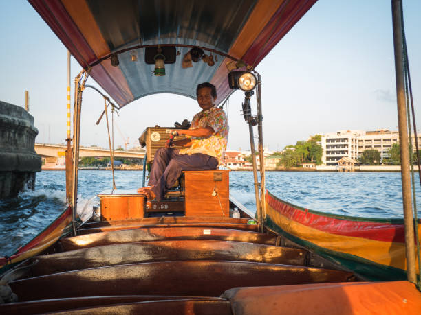 l'uomo sta guidando una barca su - bangkok thailand asia water taxi foto e immagini stock