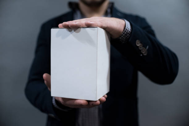 istock a man in a jacket and shirt holding a white paper box 1079158992