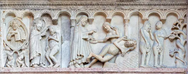 Modena - The romanesque relief of creation of the man and woman on the facade of Duomo di Modena.