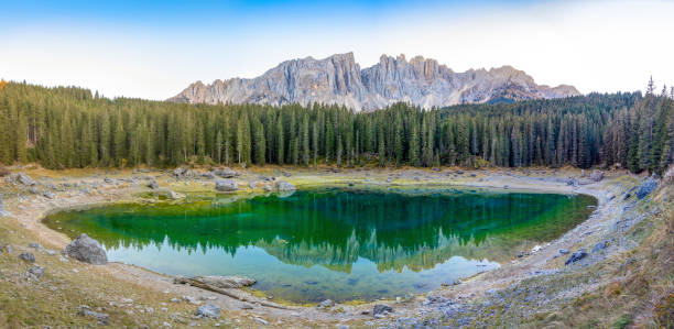karersee ou lago di carezza, est un lac avec la chaîne de montagnes du groupe latemar sur fond dans les dolomites au tyrol, italie - latemar mountain range photos et images de collection