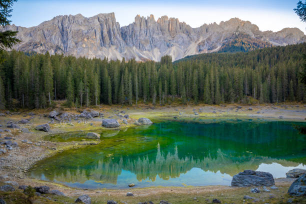 karersee ou lago di carezza, est un lac avec la chaîne de montagnes du groupe latemar sur fond dans les dolomites au tyrol, italie - latemar mountain range photos et images de collection