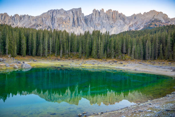 karersee ou lago di carezza, est un lac avec la chaîne de montagnes du groupe latemar sur fond dans les dolomites au tyrol, italie - latemar mountain range photos et images de collection