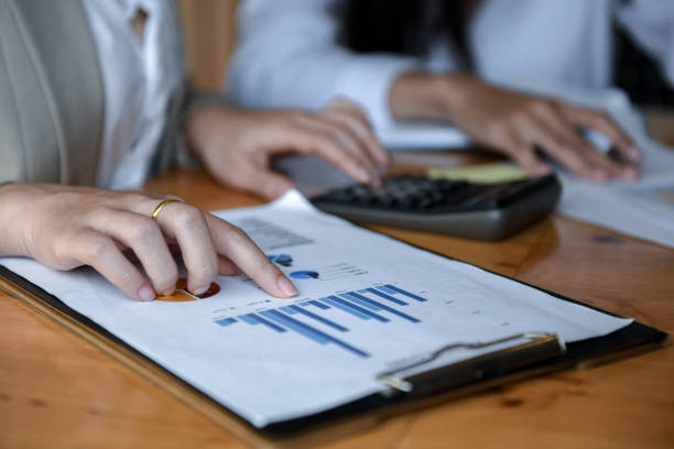 istock Girl office using a calculator to graphs analysis. 1079162650