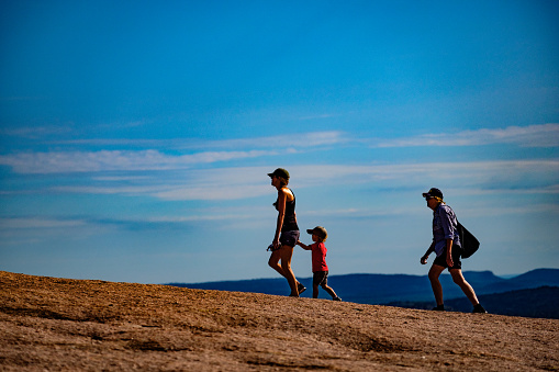 Enchanted Rock is a pink granite mountain located in the Llano Uplift approximately 17 miles north of Fredericksburg, Texas. It and the surrounding 1,644 acres are a Texas State Park. Here some day hikers enjoy the area.