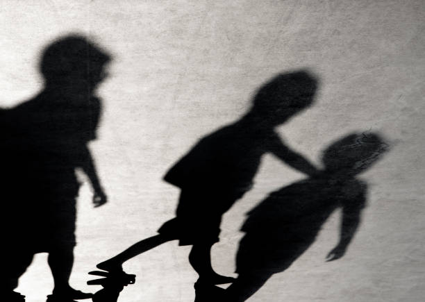 blurry shadows of three boys - sombra em primeiro plano imagens e fotografias de stock