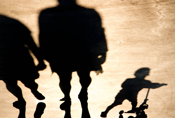 istock Blurry shadow of parents with a child on a push scooter 1079175520
