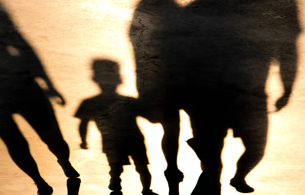 istock Blurry shadow of a boy and adults walking 1079177158