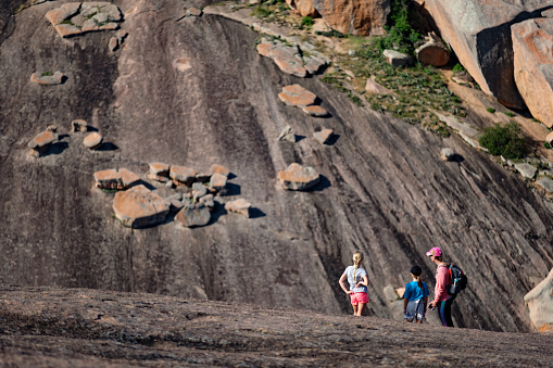 Enchanted Rock is a pink granite mountain located in the Llano Uplift approximately 17 miles north of Fredericksburg, Texas. It and the surrounding 1,644 acres are a Texas State Park. Here some day hikers enjoy the area.