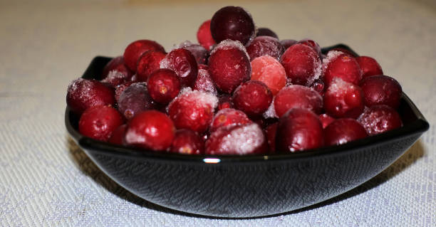 istock Frozen cranberries in a black bowl table covered with white cloth 1079179520