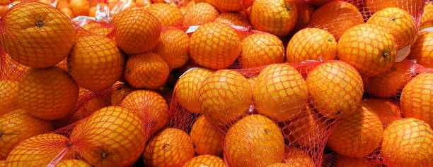 istock Fresh oranges in plastic mesh sack on the shelf in the store 1079179556