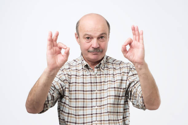 istock Senior man showing ok sign standing isolated on gray background 1079181530