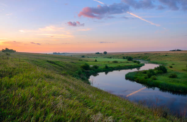 istock Summertime scene.Morning calm.Tranquil summer landscape with river bend.Twilight.Minutes before the sunrise.Beautiful view with lush meadows and pastures. 1079185236
