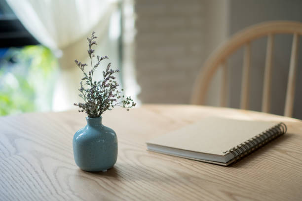 istock A flower in bottle jar and notebook on the the wood table in coffee shop. 1079185444