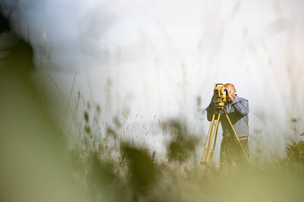 Surveyor Using Theodolite to Measure Land Surveyor Using Theodolite to Measure Land. surveyor photos stock pictures, royalty-free photos & images