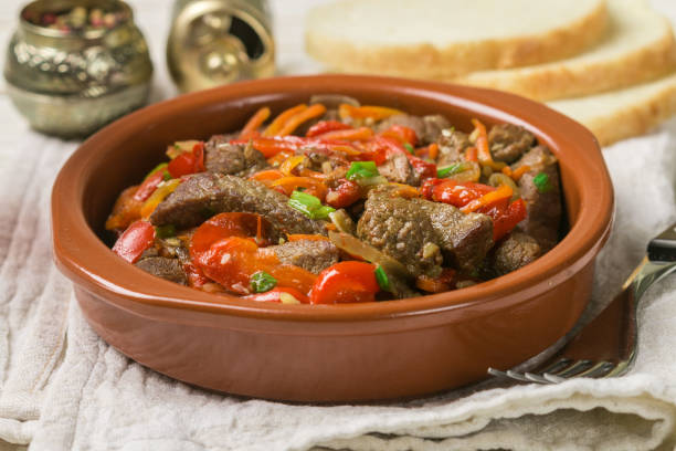 istock Beef stewed with vegetables-carrots, bell peppers, onions, garlic and spices in ceramic form. A delicious gourmet dinner.  Selective focus 1079221914