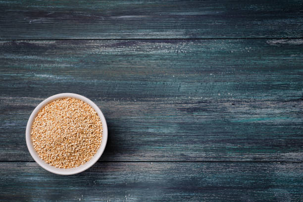 istock Organic quinoa seeds in a ceramic bowl on wooden green rustic table. 1079234196