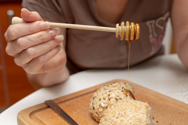 istock Tasty wheat roll on the kitchen table. Preparing dinner with fresh bread and honey. Autumn background. 1079242484