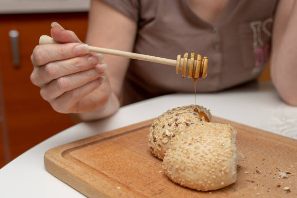 istock Tasty wheat roll on the kitchen table. Preparing dinner with fresh bread and honey. Autumn background. 1079246182